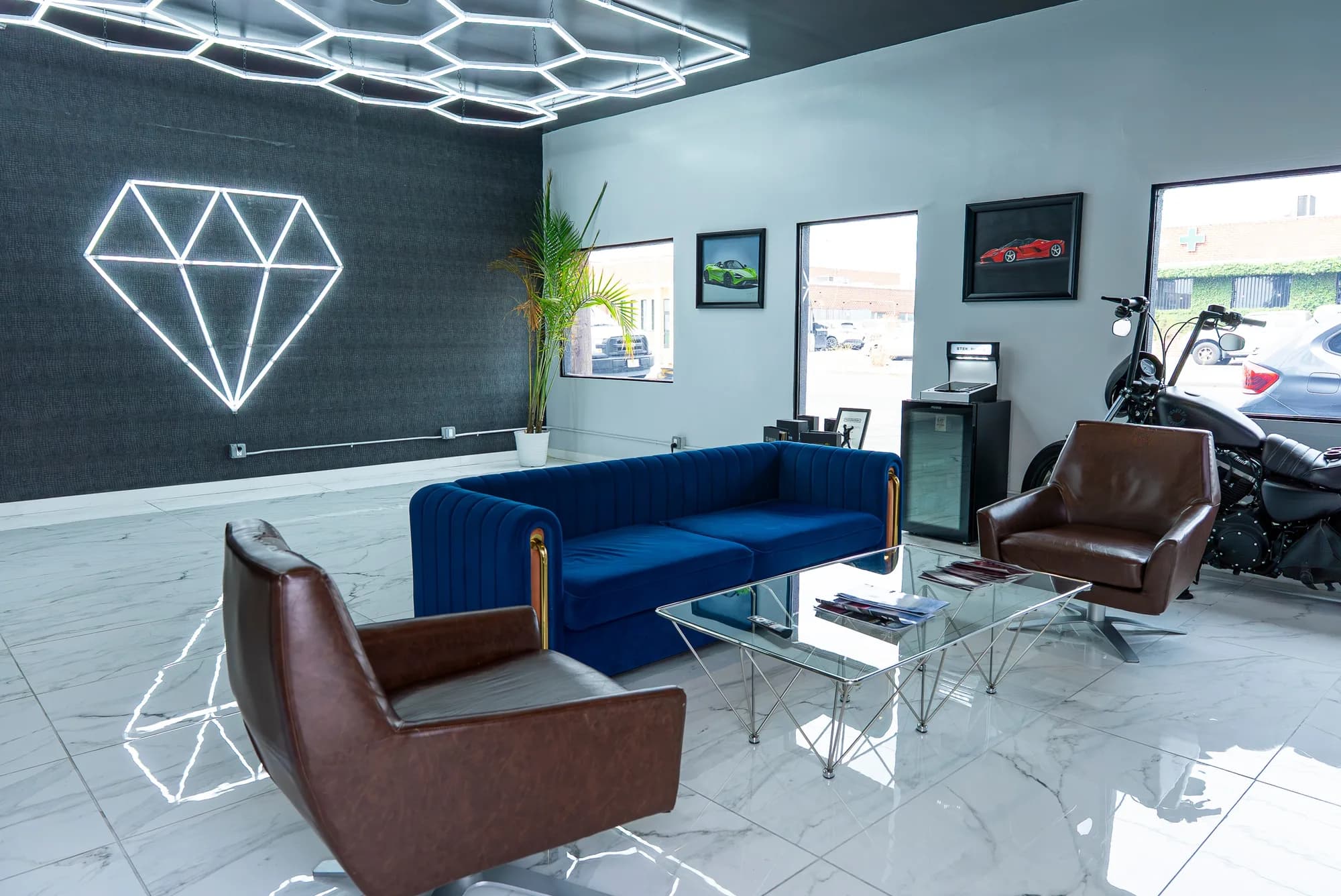 The GEM Collision customer lounge: a lit diamond wall feature, seating, and marble-look flooring